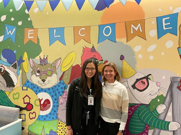 Dr. Jeannette Stallworth and Dr. Erin Herlihy in front of a new mural in the Seattle Children's ophthalmology clinic created by former faculty member Dr. Carmela Mercado. 